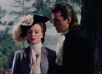 Movie still from “Saraband” (1948), directed by Basil Dearden – A man and a woman standing next to each other; Medium shot, Over the shoulder angle