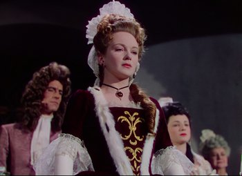 Movie still from “Saraband” (1948), directed by Basil Dearden – A woman dressed in renaissance clothing and a wig; Medium shot, Low angle