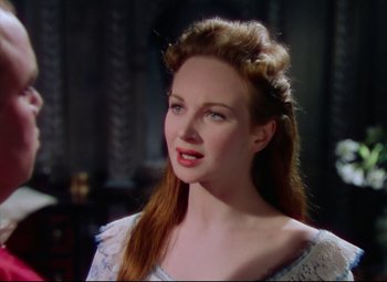 Movie still from “Saraband” (1948), directed by Basil Dearden – A woman with long red hair wearing a white dress; Close Up shot, Over the shoulder angle