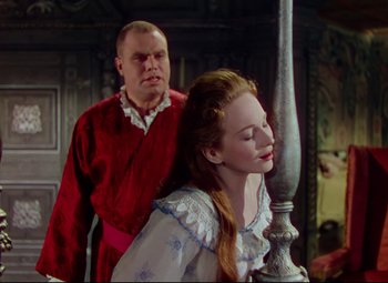 Movie still from “Saraband” (1948), directed by Basil Dearden – A man standing next to a beautiful woman; Medium shot, Over the shoulder angle