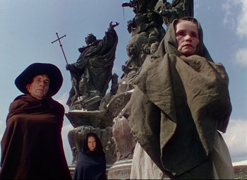 Movie still from “Saraband” (1948), directed by Basil Dearden – A group of people standing next to a statue; Wide shot, Low angle