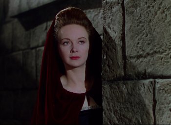 Movie still from “Saraband” (1948), directed by Basil Dearden – A woman in a red dress standing next to a stone wall; Close Up shot, High angle