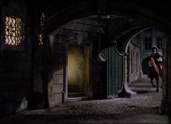 Movie still from “Saraband” (1948), directed by Basil Dearden – An open door in a stone building with arches; Extreme Wide shot, High angle