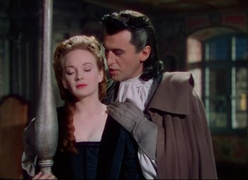 Movie still from “Saraband” (1948), directed by Basil Dearden – A man and a woman are standing next to each other; Medium shot, Over the shoulder angle