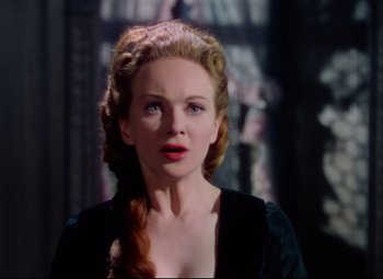Movie still from “Saraband” (1948), directed by Basil Dearden – A woman with long red hair wearing a black dress; Close Up shot, Over the shoulder angle