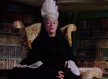 Movie still from “Saraband” (1948), directed by Basil Dearden – An older woman wearing a black dress and a white headdress; Medium shot, Low angle