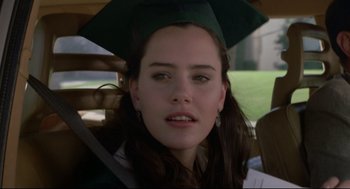 Movie still from “Say Anything” (1989), directed by Cameron Crowe – A woman in a graduation cap sitting in a car; Close Up shot, Over the shoulder angle
