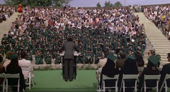 Movie still from “Say Anything” (1989), directed by Cameron Crowe – A group of people sitting in front of an audience; Extreme Wide shot, High angle