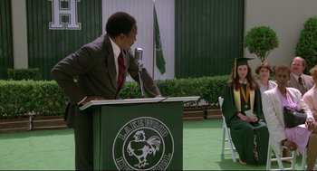 Movie still from “Say Anything” (1989), directed by Cameron Crowe – A man is giving a speech at a graduation ceremony; Wide shot, Over the shoulder angle