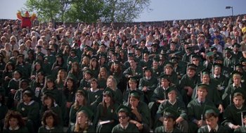 Movie still from “Say Anything” (1989), directed by Cameron Crowe – A large group of people wearing green caps and gowns; Wide shot, High angle