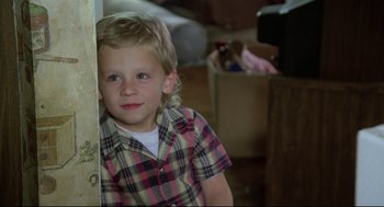 Movie still from “Say Anything” (1989), directed by Cameron Crowe – A little boy standing next to a wall in a room; Close Up shot, High angle