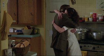 Movie still from “Say Anything” (1989), directed by Cameron Crowe – A man and a woman hugging in a kitchen; Medium shot, Over the shoulder angle