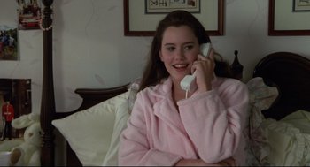 Movie still from “Say Anything” (1989), directed by Cameron Crowe – A woman in a pink robe talking on a phone; Medium shot, High angle