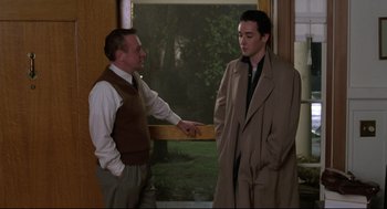 Movie still from “Say Anything” (1989), directed by Cameron Crowe – Two men standing next to each other in front of a window; Medium shot, Over the shoulder angle