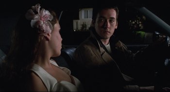 Movie still from “Say Anything” (1989), directed by Cameron Crowe – A man and a woman sitting in the back of a car; Close Up shot, Over the shoulder angle
