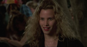 Movie still from “Say Anything” (1989), directed by Cameron Crowe – A woman with long blonde curly hair smiling for the camera; Close Up shot, Over the shoulder angle