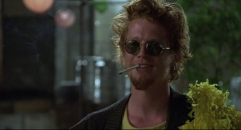 Movie still from “Say Anything” (1989), directed by Cameron Crowe – A person wearing sunglasses and holding a cigarette; Close Up shot, Low angle