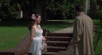 Movie still from “Say Anything” (1989), directed by Cameron Crowe – A woman in a white dress standing next to a man; Medium shot, Over the shoulder angle