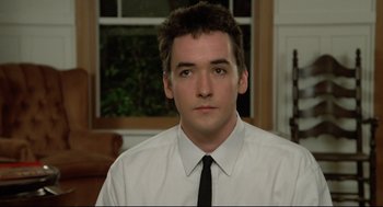 Movie still from “Say Anything” (1989), directed by Cameron Crowe – A man in a white shirt and a black tie; Close Up shot, Low angle