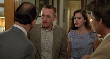 Movie still from “Say Anything” (1989), directed by Cameron Crowe – A group of people standing next to each other in a room; Medium shot, Over the shoulder angle