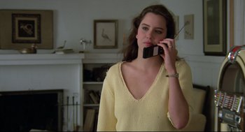 Movie still from “Say Anything” (1989), directed by Cameron Crowe – A woman in a yellow shirt talking on a cell phone; Close Up shot, Low angle
