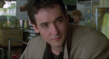 Movie still from “Say Anything” (1989), directed by Cameron Crowe – A person wearing a suit and tie; Close Up shot, Over the shoulder angle