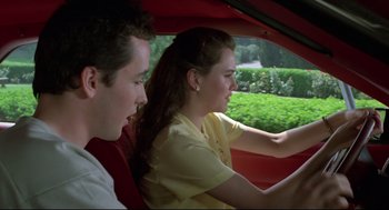 Movie still from “Say Anything” (1989), directed by Cameron Crowe – A man and a woman in a red car; Medium shot, Over the shoulder angle