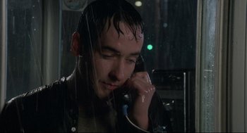 Movie still from “Say Anything” (1989), directed by Cameron Crowe – A man talking on a cell phone in the rain; Close Up shot, Low angle
