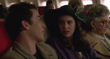 Movie still from “Say Anything” (1989), directed by Cameron Crowe – A man and a woman sitting next to each other on a plane; Close Up shot, Over the shoulder angle