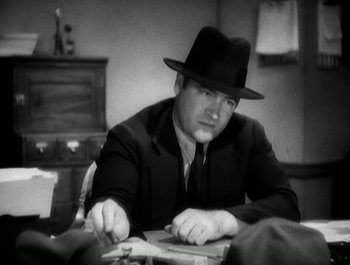 Movie still from “Scarface” (1932), directed by Richard Rosson – A black and white photo of a man wearing a hat; Close Up shot, Low angle