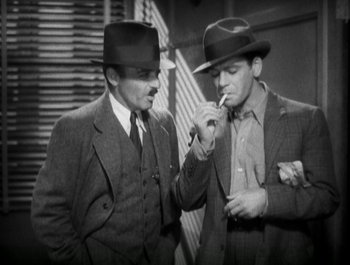 Movie still from “Scarface” (1932), directed by Richard Rosson – A couple of men standing next to each other; Medium shot, High angle