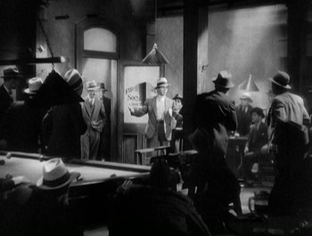 Movie still from “Scarface” (1932), directed by Richard Rosson – A black and white photo of a group of men in suits and hats; Wide shot, High angle