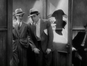 Movie still from “Scarface” (1932), directed by Richard Rosson – A black and white photo of two men in suits and hats; Medium shot, High angle