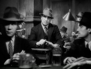 Movie still from “Scarface” (1932), directed by Richard Rosson – A group of men sitting around a table; Medium shot, Low angle