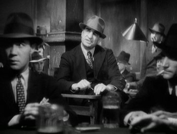 Movie still from “Scarface” (1932), directed by Richard Rosson – A group of men sitting at a table wearing suits and hats; Medium shot, Low angle