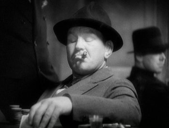 Movie still from “Scarface” (1932), directed by Richard Rosson – An old photo of a man in a suit and a hat; Close Up shot, Low angle