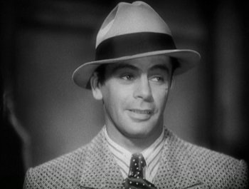 Movie still from “Scarface” (1932), directed by Richard Rosson – A man wearing a suit and a hat; Close Up shot, High angle