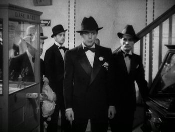 Movie still from “Scarface” (1932), directed by Richard Rosson – A group of men wearing suits and hats; Medium shot, Low angle