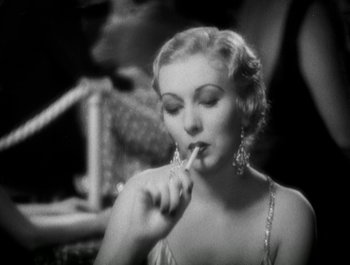 Movie still from “Scarface” (1932), directed by Richard Rosson – An old photo of a woman with a cigarette in her mouth; Close Up shot, High angle