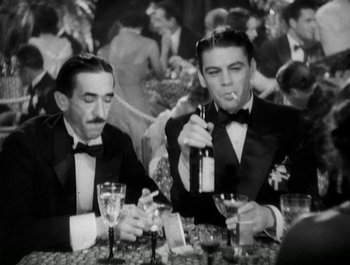 Movie still from “Scarface” (1932), directed by Richard Rosson – Two men in tuxedos sitting at a table with drinks; Medium shot, High angle