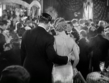 Movie still from “Scarface” (1932), directed by Richard Rosson – A man and a woman holding hands in front of a crowd; Medium shot, Low angle