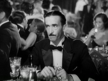 Movie still from “Scarface” (1932), directed by Richard Rosson – A black and white photo of a man sitting at a table; Close Up shot, Over the shoulder angle