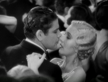 Movie still from “Scarface” (1932), directed by Richard Rosson – A man and a woman kissing each other in front of a crowd of onlookers; Close Up shot, High angle