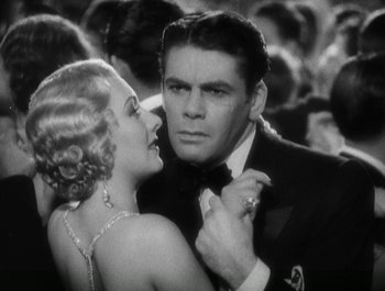 Movie still from “Scarface” (1932), directed by Richard Rosson – A man and a woman in formal wear in a crowd of onlookers; Close Up shot, Over the shoulder angle