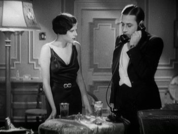 Movie still from “Scarface” (1932), directed by Richard Rosson – A man and a woman standing next to each other; Medium shot, High angle