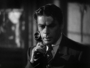Movie still from “Scarface” (1932), directed by Richard Rosson – A black and white photo of a man holding a camera; Close Up shot, Low angle