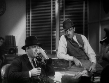 Movie still from “Scarface” (1932), directed by Richard Rosson – Two men sitting at a table talking on the phone; Medium shot, High angle