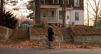 Movie still from “Scent of a Woman” (1992), directed by Martin Brest – A man standing next to a bicycle in front of a house; Wide shot, High angle