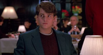Movie still from “Scent of a Woman” (1992), directed by Martin Brest – A young man in a suit and a red sweater; Close Up shot, Over the shoulder angle