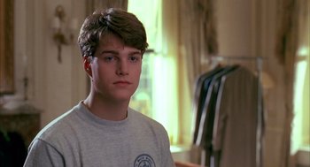 Movie still from “Scent of a Woman” (1992), directed by Martin Brest – A young man is looking at the camera while standing in front of a closet; Close Up shot, Over the shoulder angle